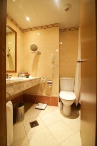 a bathroom with a toilet and a sink at Hala Hotel & Aqua Park in Bissau