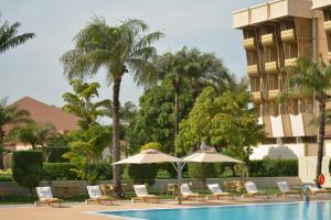 a pool with chairs and umbrellas next to a hotel at Hala Hotel & Aqua Park in Bissau