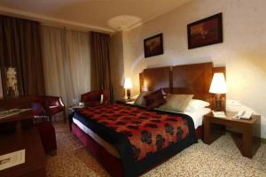 Habitación de hotel con cama grande y escritorio. en Hala Hotel & Aqua Park en Bissau