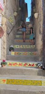 two women walking up the stairs of a building at Borgo di Santa Barbara in Santa Domenica