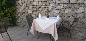 a table with a white table cloth and a vase of flowers on it at Borgo di Santa Barbara in Santa Domenica