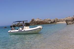 a boat sitting in the water on a beach at Borgo di Santa Barbara in Santa Domenica