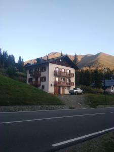 a building on the side of a road with a car at Appartemento Casa Giuli in Passo del Tonale