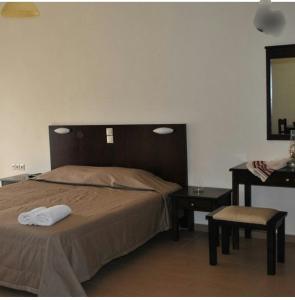 a bedroom with a bed and a table and a mirror at Xenonas Anopolis 1 in Anopoli Sfakion