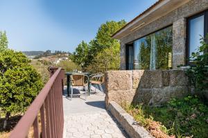a balcony with a table and chairs on a house at Partezins III in Castelo de Paiva