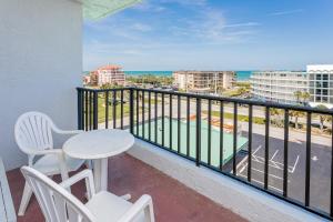 een balkon met een tafel en stoelen en uitzicht op de oceaan bij Beachside Hotel and Suites in Cocoa Beach