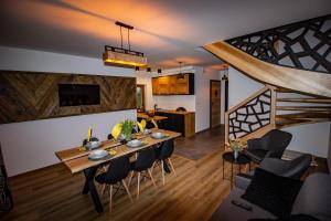 a dining room and kitchen with a table and chairs at EM Gorce Resort komfortowe domki z sauną i jacuzzi in Waksmund
