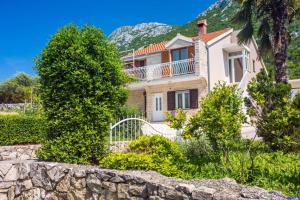 a large house with a stone wall and trees at Apartment Birdie with private pool and mini golf in Gata