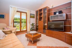 a living room with a large television and a couch at Apartment Birdie with private pool and mini golf in Gata