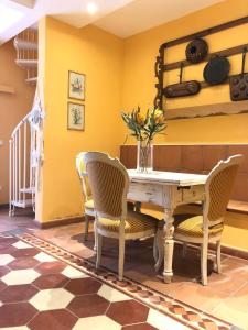 comedor con paredes amarillas, mesa y sillas en Luxury House Il Borgo Antico, en Casale Marittimo