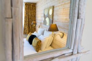 a mirror reflection of a bed in a bedroom at Hôtel Le Peu Breton in Sainte-Marie-de-Ré