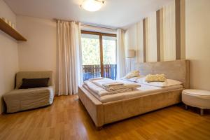1 dormitorio con 1 cama, 1 silla y 1 ventana en Fatrapark 2 Apartments HRABOVO - Hlavná recepcia, en Ružomberok