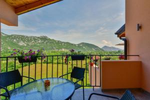 a balcony with a glass table and chairs at Lakeview Apartments Anđela in Virpazar