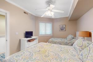 ein Schlafzimmer mit zwei Betten und einem Deckenventilator in der Unterkunft Adagio in Ocean City