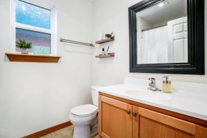 a bathroom with a toilet and a sink and a mirror at Little Blue Beach House in Pacific Beach +21 photos