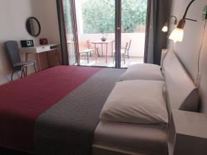 a bedroom with a large bed and a balcony at Apartament Oliva in Vrsar +15 photos