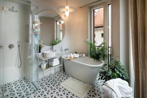 a bathroom with a tub and two sinks and a mirror at Redstone Apartments in Rīga