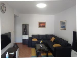 a living room with a black couch and a tv at Apartament Oliva in Vrsar