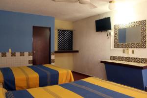 a motel room with two beds and a television at Hotel California in Mazatlán +3 photos