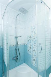 a bathroom with a shower with a glass door at Merino Home Family in Saint Petersburg