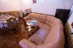 a living room with a leather couch and a table at Casa Albă in Baia de Aramă