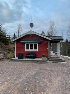 uma casa vermelha com um sofá em frente em Lillhuset Norr Sälens By em Sälen