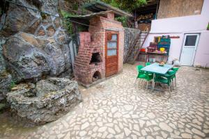 a patio with a table and a brick oven at Casa Albă in Baia de Aramă