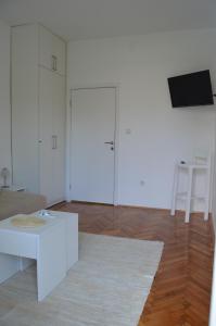 a white living room with a couch and a table at Gospostina Apartments in Budva