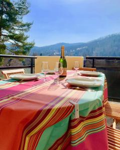 - une table avec une bouteille de vin et des verres dans l'établissement Gite "Au Pied des Vignes" à Kaysersberg, à Kaysersberg