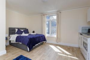 a white bedroom with a bed and a window at St Mary's - Modern Central Huge Studio Apartments in Southampton