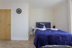 una camera con un letto e un orologio a muro di St Mary's - Modern Central Huge Studio Apartments a Southampton