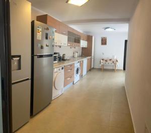 a kitchen with a refrigerator and a washer and dryer at Casa Bianca Oncesti in Onceşti