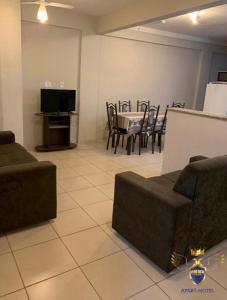 ein Wohnzimmer mit einem Sofa, einem Tisch und Stühlen in der Unterkunft Golden Apart Hotel in Aparecida