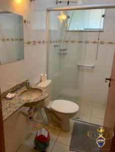 ein Bad mit einer Dusche, einem WC und einem Waschbecken in der Unterkunft Golden Apart Hotel in Aparecida