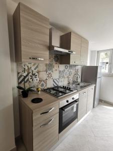 a kitchen with wooden cabinets and a stove top oven at Emidio House in Termini