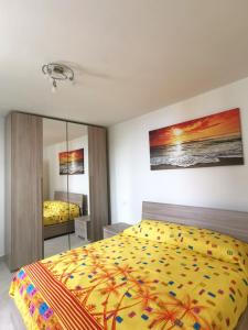 a bedroom with a yellow bed and a mirror at Emidio House in Termini