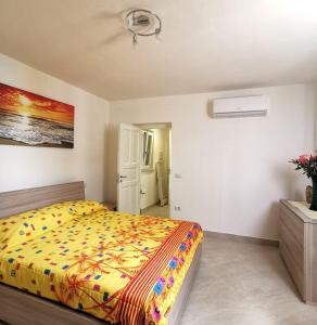 a bedroom with a bed with a yellow comforter at Emidio House in Termini