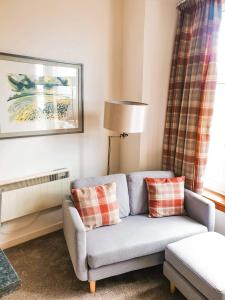 a living room with a couch and a lamp at Apartment D 4 Battery Terrace Oban in Oban