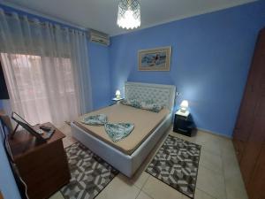 um quarto com uma cama num quarto azul em Bral Apartment 3 em Durrës