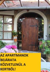 een toegang tot een huis met een houten deur bij Arlekin Apartman in Hévíz