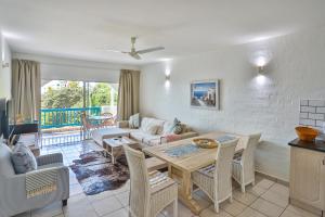 uma sala de estar com uma mesa e um sofá em Serenity At Sea - Santorini Estate - FAMILY ONLY em Ballito