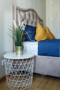 a bed with blue and yellow pillows and a table at Merino Home Family in Saint Petersburg