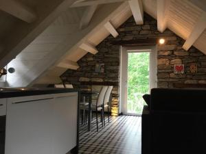 uma cozinha com uma parede de pedra com uma mesa e cadeiras em CASA DELLA NONNA em Croveo