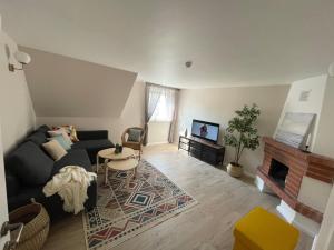 un soggiorno con divano e camino di Juodkrantes apartamentai a Juodkrantė