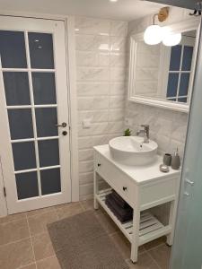 un bagno bianco con lavandino e specchio di Juodkrantes apartamentai a Juodkrantė Altre 18 foto