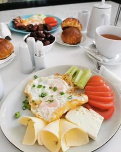 a plate of food with eggs and cheese and vegetables at Guest rooms Denicija in Skopje