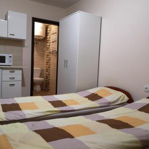 sypialnia z 2 łóżkami oraz kuchnia z kuchenką mikrofalową w obiekcie noclegi u Adama w mieście Kajetany