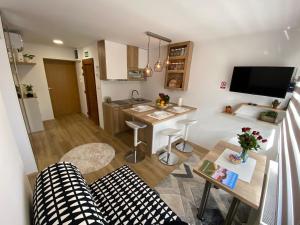 a living room with a couch and a kitchen with a table at Apartman Edita in Virovitica