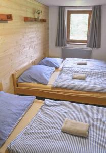 three beds in a room with blue and white sheets at Chata Aktiv in Vernířovice