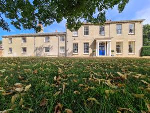 a large building with a grass field in front of it at Sloley Hall in Tunstead